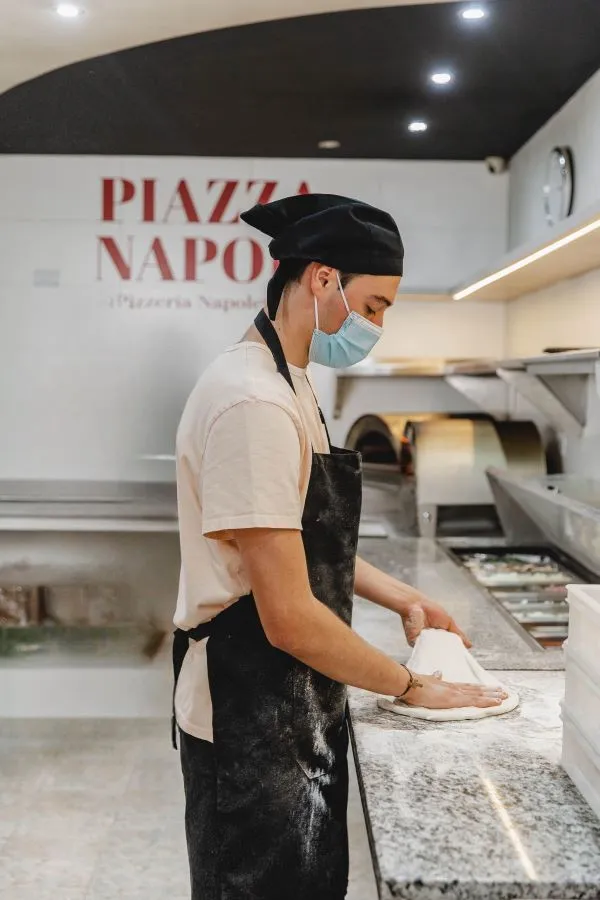 Pizzaiolo estirando masa de pizza napoletana