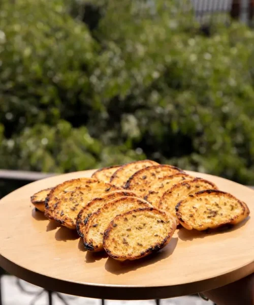 Pan al ajo sobre una tabla de madera al sol.