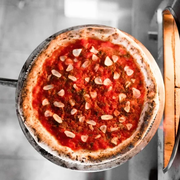 Pizza Marinara con salsa de tomate, ajo laminado y orégano.