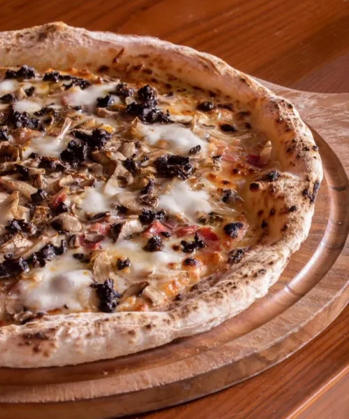 Pizza Tartufo e Funghi sobre la mesa